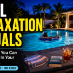 A person floating peacefully on a blue raft in a brightly lit backyard pool at night. In the foreground, a patio chair holds a striped towel, an iced beverage, a portable speaker, and a book titled "It's Okay to Slow Down". Text overlay reads: "Pool Relaxation Rituals - Easy Things You Can Actually Do In Your Florida Pool. Simple - Realistic - Relaxing